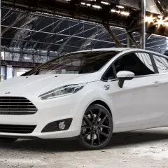 Weißer Ford Fiesta mit schwarzen Felgen in einer Industriehalle.