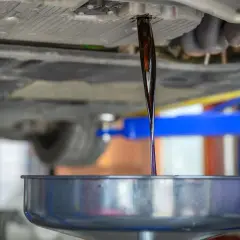 Altöl fließt aus dem Getriebe eines Autos in eine Auffangschale.