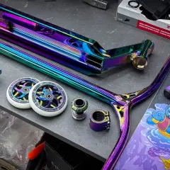 Bunte Stunt-Scooter-Teile: Deck, Gabel, Lenker, Rollen und Griffe.