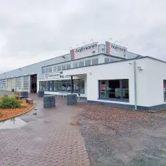 Gebäude von Reifen Hofmann Bebra mit roten Auto davor.