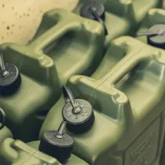 Mehrere grüne Benzinkanister mit schwarzen Verschlüssen und Griffen.