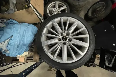 Mehrere Autoreifen, darunter ein silberner Alufelgen-Reifen im Vordergrund.