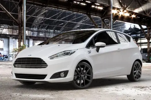 Weißer Ford Fiesta mit schwarzen Felgen in einer Industriehalle.