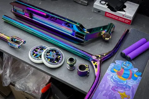 Bunte Stunt-Scooter-Teile: Deck, Gabel, Lenker, Rollen und Griffe.