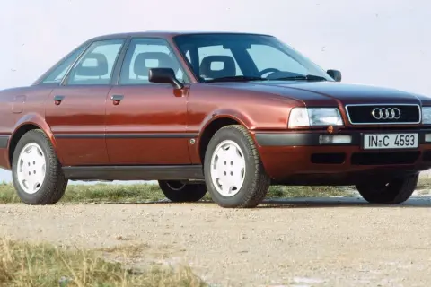 Roter Audi 80 B4 Limousine von vorne rechts auf Schotterweg.
