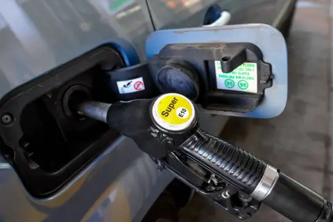 Zapfsäule mit E10-Kennzeichnung wird in einen Tankstutzen eingeführt.