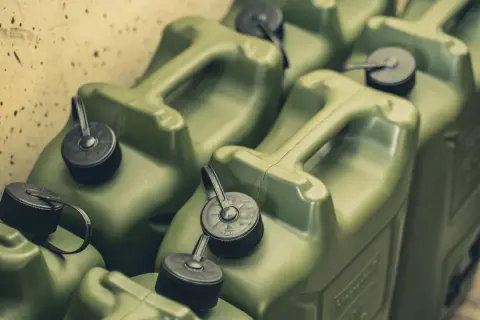 Mehrere grüne Benzinkanister mit schwarzen Verschlüssen und Griffen.