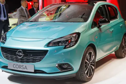 Türkisfarbener Opel Corsa mit Schriftzug "Corsa" auf dem Kühlergrill.