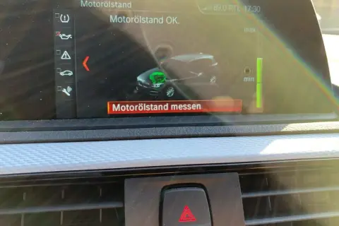 BMW F21 Display zeigt Motorölstand OK mit Messbalken und Auto-Symbol.