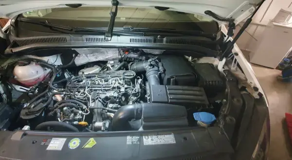 Motorraum eines VW Golf 7 1.6 TDI mit geöffneter Motorhaube.